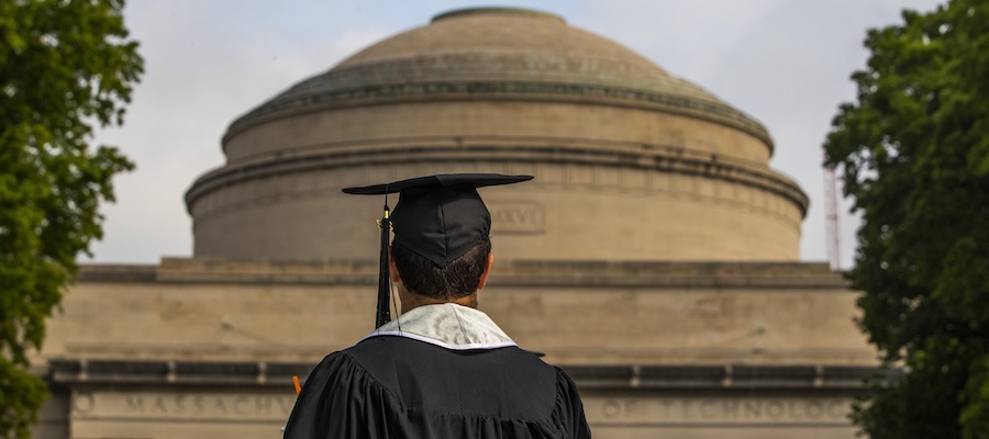 Image of graduate looking at the building 10 dome on Killian Court