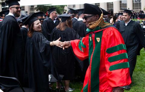 Faculty member shaking graduates hand