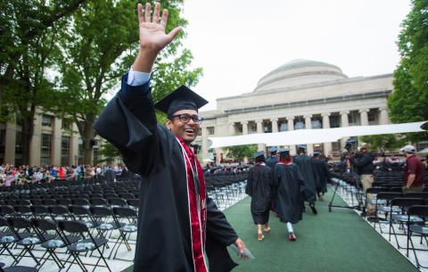 Image of graduate waving in front of Killian Court