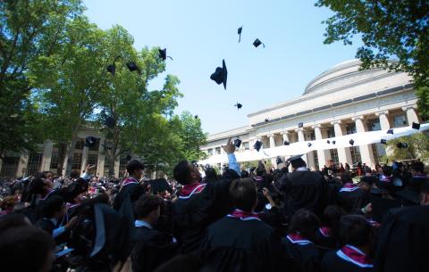 Image of graduates throwing their caps in the air following the diploma distribution