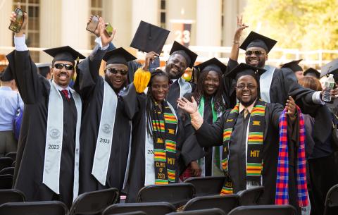 Image of group of graduates smiling and waving