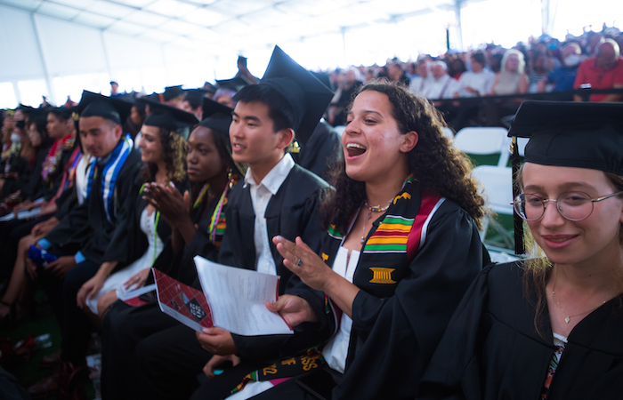 Image of undergraduate students cheering in the audience at the Undergraduate Ceremony