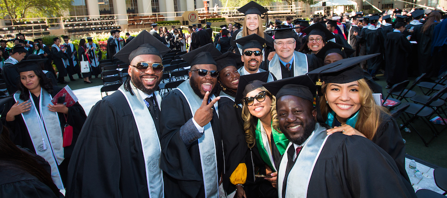 Image of graduates smiling and posing for the camera