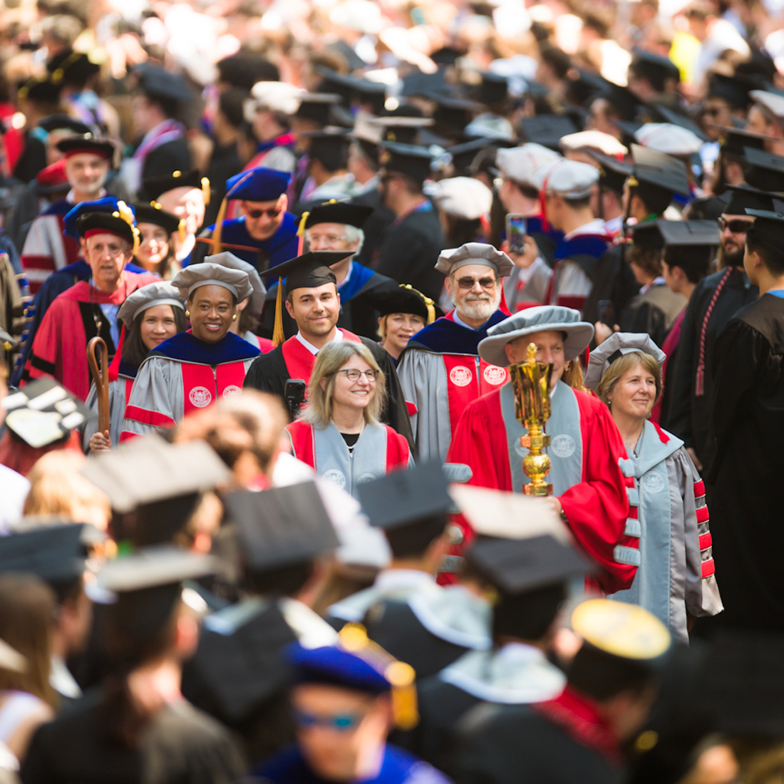 Stephen D. Baker ’84 MArch ’88 led the procession of faculty and administration to the stage carrying the ceremonial golden mace. MIT President Sally Kornbluth walked on his right, and Corporation Chair Diane Greene SM ’78 walked on his left. Image: Gretchen Ertl