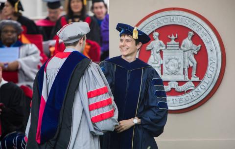 A member of the faculty awards a diploma to one of MIT's newest PhDs; photo: Jake Belcher