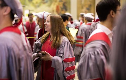 Female doctoral candidate smiles as she prepares for the procession; photo: Jake Belcher