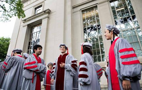 Doctoral candidates converse while in procession; photo: Jake Belcher