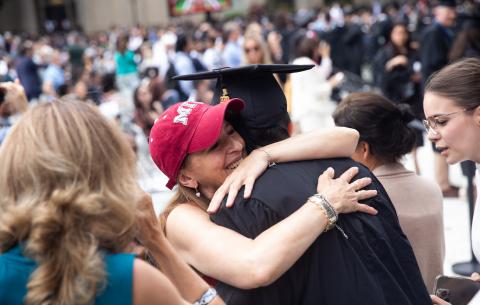 Image of a family member hugging a graduate at the Special Ceremony for the Classes of 2020 and 2021