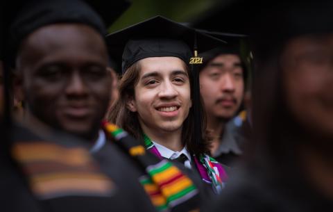 Image of graduate smiling while seated at the Special Ceremony for the Classes of 2020 and 2021