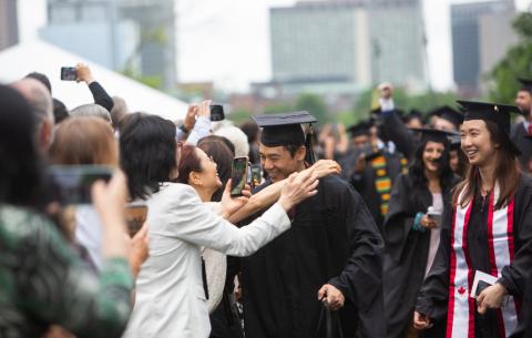 Image of graduate hugging family member in the audience at the Special Ceremony for the Classes of 2020 and 2021