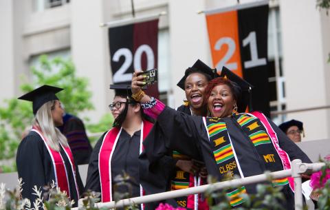Image of graduates taking a photo of themselves while on stage at the Special Ceremony for the Classes of 2020 and 2021