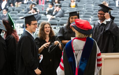 Image of a faculty member congratulating students on the stage at the Special Ceremony for the Classes of 2020 and 2021