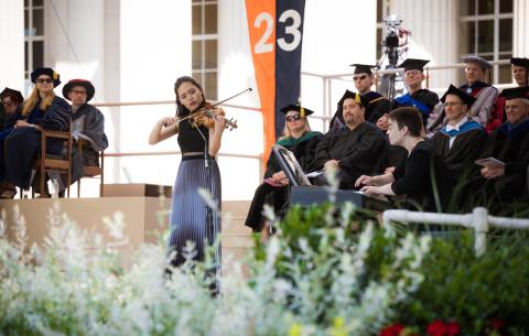 Image of graduate Shelley Choi playing the violin during the ceremony. Her accompanist, Anna Arazi is seen to the right of her accompanying her on the piano