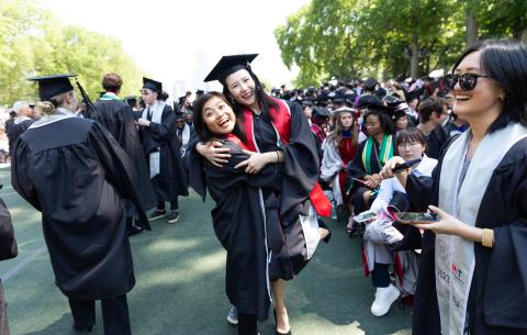 Image of two female 2023 graduates embracing with smiles on their faces