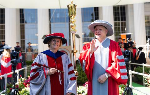 Image of Leslie Kolodziejski and Stephen D. Baker at the front of the Killian Court stage, watching the academic procession ascend the stage