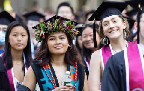 Image of female graduates smiling during the OneMIT Commencement Ceremony