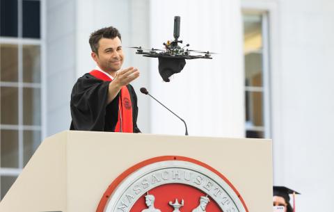 Image of Mark Rober letting go of his grad cap, which is attached to a drone