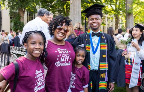 Image of a family smiling celebrating their graduate. The family is wearing t-shirts that read, "Proud Mom/Sister of a 2023 MIT graduate"