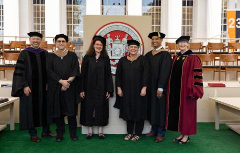 Image of the staff members who red names during the Undergraduate Ceremony. They are all wearing regalia and smiling at the camera.